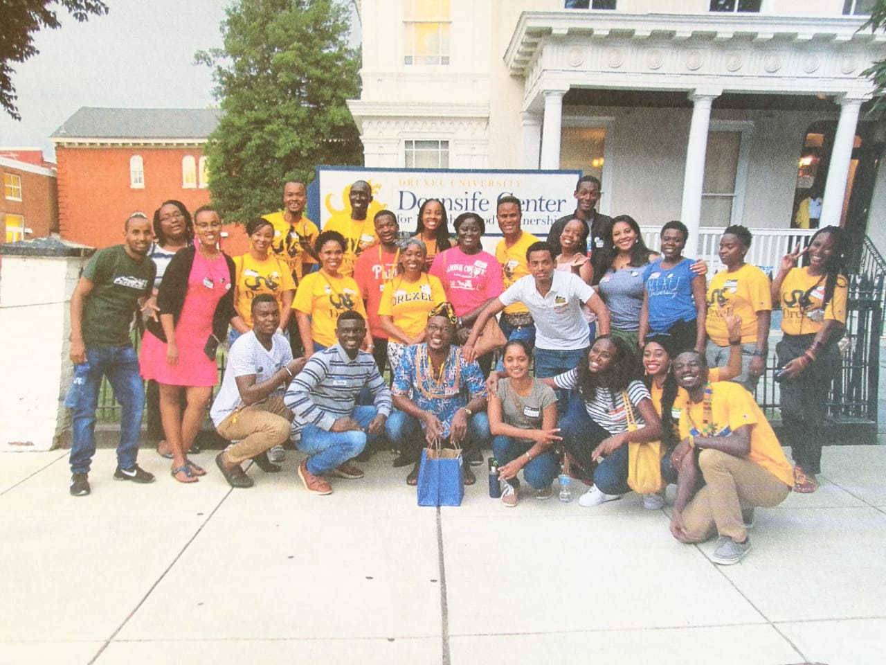 Image of the Fellows kneeling in front of the Dornsife Center sign.